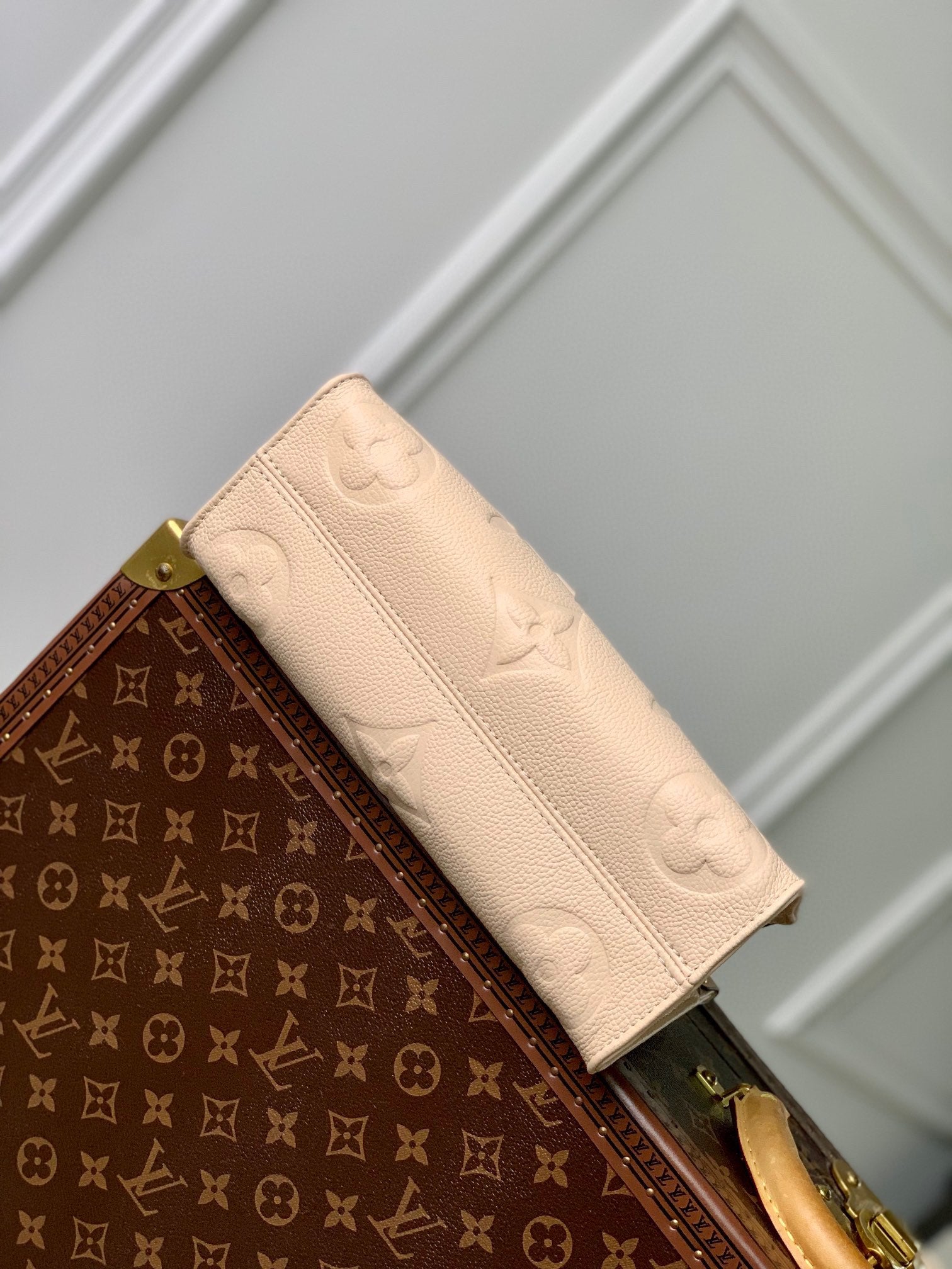 SAC ONTHEGO EST-OUEST 25 EN CUIR DE VACHE BEIGE MONOGRAMMÉ EN GAUFRAGE